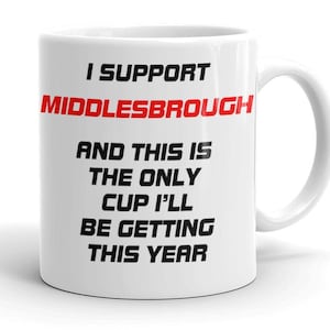 May include: White ceramic mug with the text "I SUPPORT MIDDLESBROUGH" in black and red. The mug reads "AND THIS IS THE ONLY CUP I'LL BE GETTING THIS YEAR". The mug has a white handle, perfect for tea or coffee.