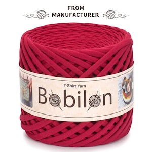 Può includere: Un gomitolo di filato di maglietta rosso della marca Bobilon. Il filato è realizzato con magliette riciclate ed è perfetto per lavorare a uncinetto o ai ferri.