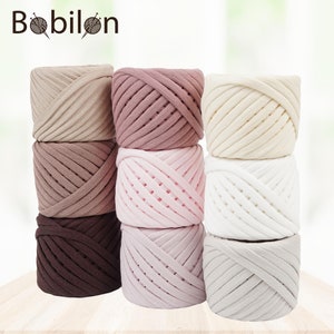 May include: A set of six balls of yarn in various shades of pink, brown, and beige. The yarn is thick and chunky, ideal for crocheting or knitting.
