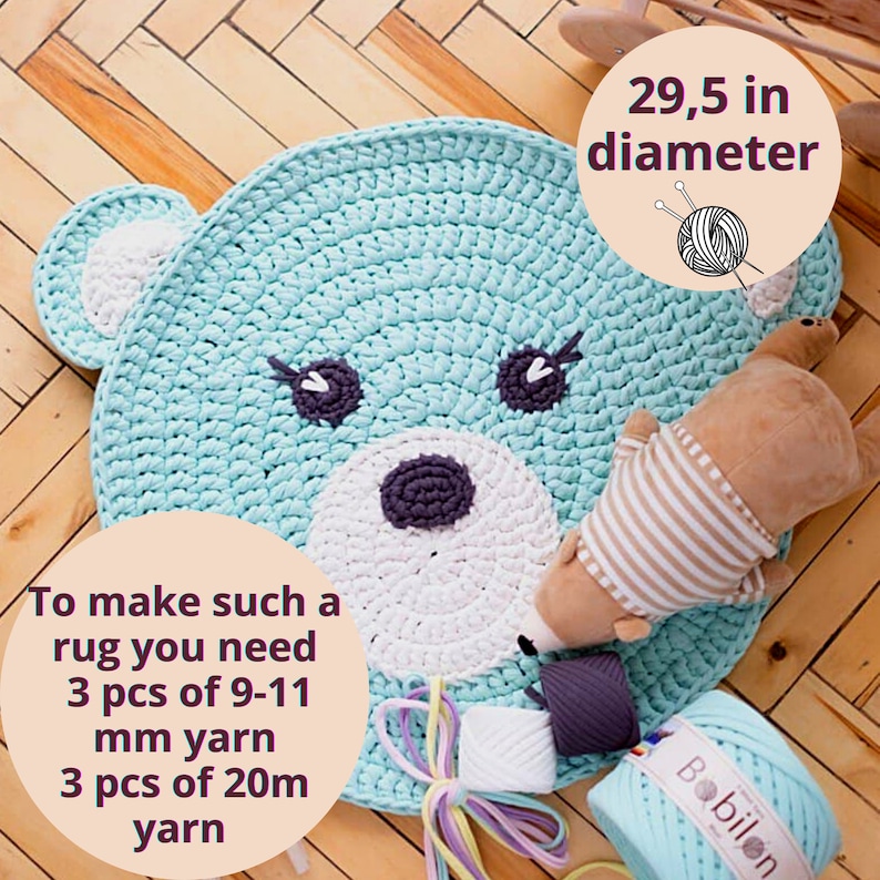 May include: A handmade, light blue crochet rug in the shape of a bear's face, with a diameter of 29.5 inches. The rug features white and dark purple accents for the face details. The image also shows yarn and a small stuffed bear.