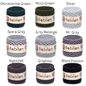 May include: Nine spools of Bobilon T-shirt yarn in various colors, including Ultramarine Green, Moss Green, Silver, Space Gray, Gray Melange, Mr. Gray, Nightfall, Graphite, and Black Passion. Each spool is labeled with the Bobilon brand name.