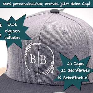 Könnte beinhalten: Eine graue Baseballkappe mit einem weißen gestickten Design eines Kranzes mit den Buchstaben "BB" darin. Die Kappe hat einen schwarzen Schirm und einen braunen Riemen. Der Text "24 Caps", "22 Garnfarben" und "16 Schriftarten" ist ebenfalls auf der Kappe zu sehen.