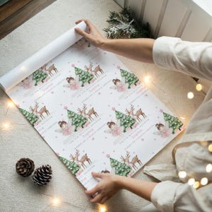 May include: White wrapping paper with a repeating pattern of a Christmas tree, reindeer, and a fairy. The text reads "For our beautiful daughter Sophie, Wishing you a magical Christmas".