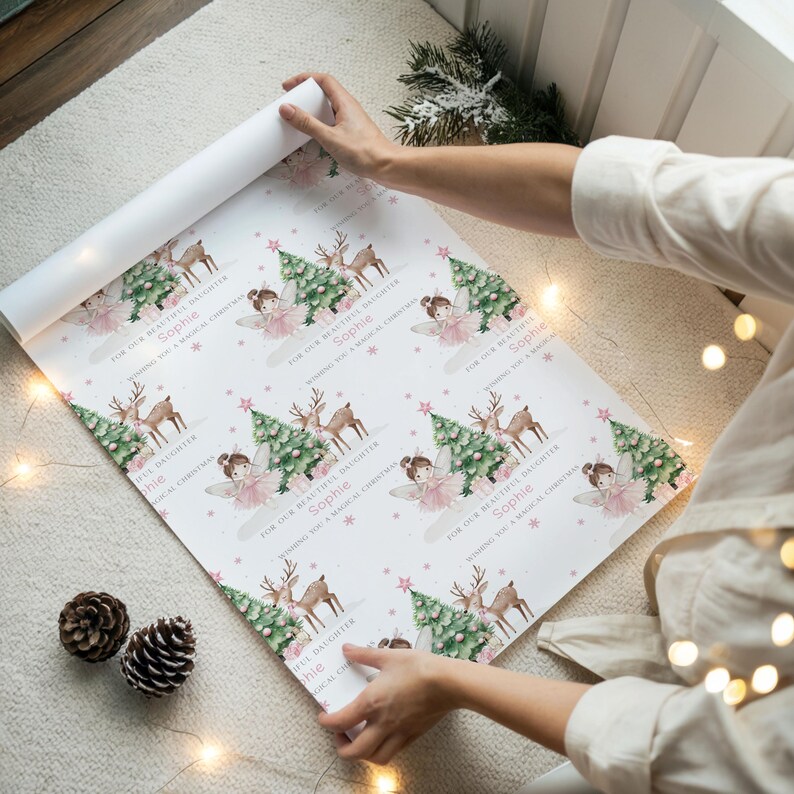 May include: White wrapping paper with a repeating pattern of a Christmas tree, reindeer, and a fairy. The text reads "For our beautiful daughter Sophie, Wishing you a magical Christmas".