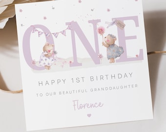 Puede incluir: Una tarjeta de cumpleaños rosa y blanca con la palabra "ONE" en letras rosas grandes. Dos ositos de peluche sostienen flores y un diente de león. La tarjeta dice "Feliz 1er cumpleaños a nuestra hermosa nieta Florence".