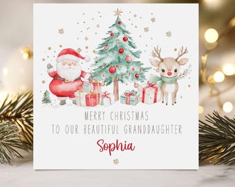 May include: A Christmas card featuring a watercolor illustration of Santa Claus, a reindeer, and a decorated Christmas tree. The card reads "Merry Christmas to our beautiful granddaughter Sophia."