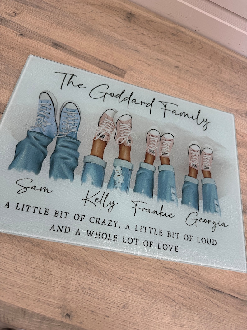 May include: A rectangular glass chopping board with the text "The Goddard Family." The image features illustrations of feet in jeans and trainers. The names Sam, Kelly, Frankie, and Georgia are printed below the illustrations, along with a quote.