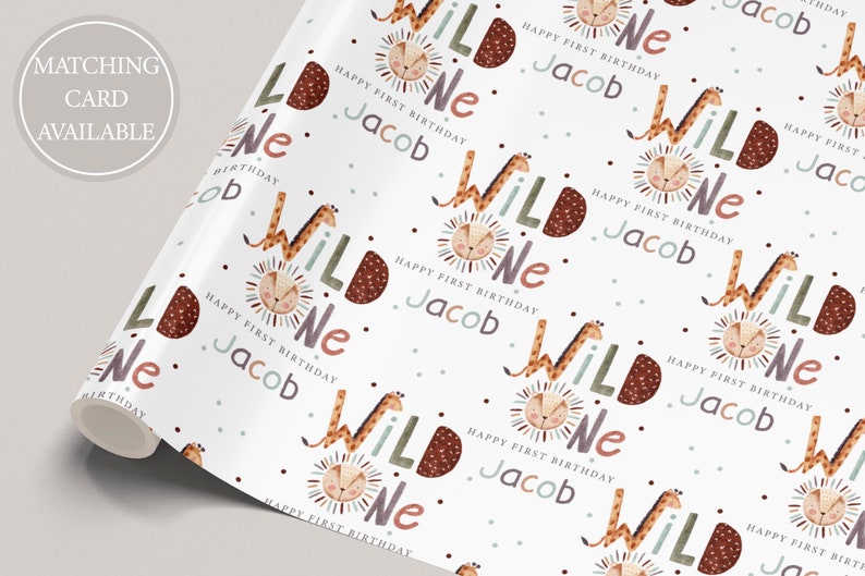 K&ouml;nnte beinhalten: Wei&szlig;es Geschenkpapier mit einem sich wiederholenden Muster aus einer Giraffe und einem L&ouml;wen mit den Worten "Wild One" und "Happy First Birthday Jacob".