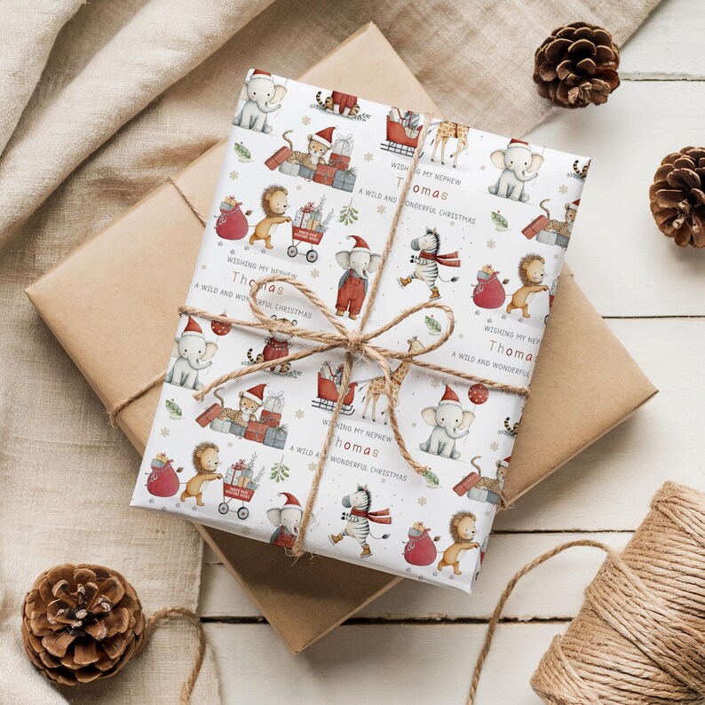 K&ouml;nnte beinhalten: Ein Geschenk, verpackt mit festlichem Geschenkpapier mit Cartoon-Tieren mit Weihnachtsm&uuml;tzen. Das Papier ist mit Bindfaden gebunden und enth&auml;lt den Text "Wishing my nephew Thomas, a wild and wonderful Christmas."