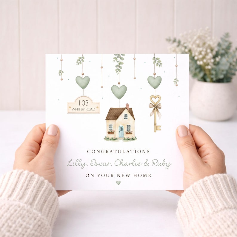 May include: A greeting card with a watercolor illustration of a house, key, and hanging hearts. The card reads "Congratulations Lilly, Oscar, Charlie & Ruby on your new home." The address "103 Whitby Road" is also displayed.