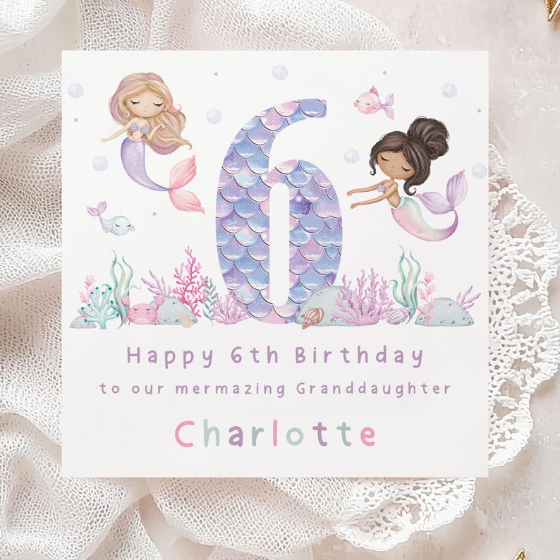 May include: A purple and blue mermaid-themed birthday card with a large number six, two mermaids, and the text "Happy 6th Birthday to our mermazing Granddaughter Charlotte".