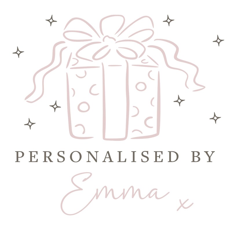 May include: A light pink line art illustration of a gift box with a bow, surrounded by small four-pointed stars. Below the gift, the text reads "PERSONALISED BY" in a dark gray sans-serif font, followed by the cursive script name "Emma x".