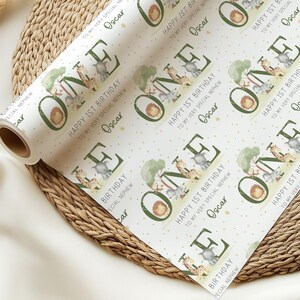 May include: White wrapping paper with a repeating pattern of green "ONE" with jungle animals and gold stars. The text "Happy 1st Birthday to my very special nephew Oscar" is repeated throughout the pattern.