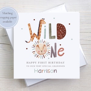 K&ouml;nnte beinhalten: Eine wei&szlig;e Karte mit einer Aquarell-Illustration einer Giraffe und eines L&ouml;wen mit dem Text "WILD One" in bunten Buchstaben. Die Karte sagt "Happy First Birthday to our very special grandson Harrison".