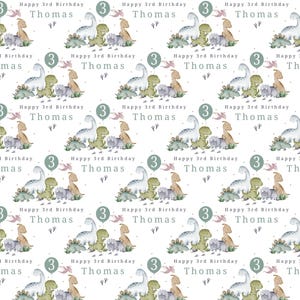 May include: A white background with a repeating pattern of green, blue, and brown dinosaurs. The text "Happy 3rd Birthday Thomas" is repeated throughout the pattern.