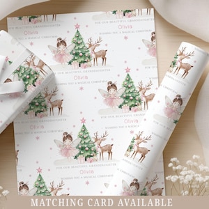 May include: Christmas-themed wrapping paper featuring a repeating pattern of fairies, reindeer, and Christmas trees on a white background. The text "For our beautiful granddaughter Olivia, wishing you a magical Christmas" is printed on the paper. A matching gift box and rolled paper are also visible.