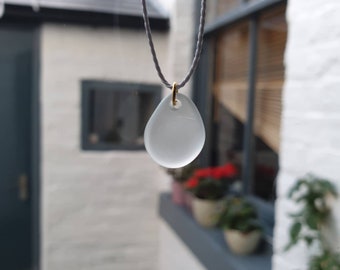Unique clear sea glass pendant necklace strung on adjustable length of light grey waxed cotton thread