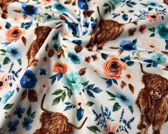 May include: White fabric with a repeating pattern of brown Highland cows and watercolor flowers in shades of blue, orange, and pink.