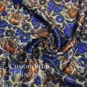 May include: Holographic fabric with a custom print featuring footballs, blue floral patterns, and the text "Custom Print Holographic". The fabric has a shiny, iridescent finish, with a mix of brown, blue, and silver tones.