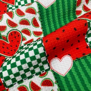 May include: A patchwork design featuring watermelon slices, hearts, and a green and white checkered pattern. The fabric has a red, green, and white color scheme. The design is reminiscent of summer and picnics.