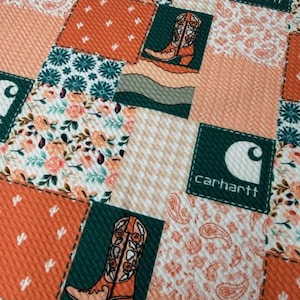 May include: A patchwork fabric design featuring squares with various patterns. The squares include floral prints, paisley, cactus motifs, and cowboy boots. The Carhartt logo is also present. The color palette consists of orange, teal, white, and cream.
