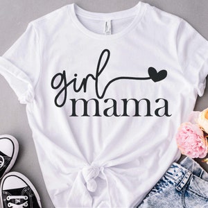 May include: White t-shirt with black text that reads "girl mama" with a small heart.