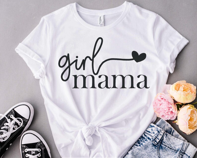 May include: White t-shirt with black text that reads "girl mama" with a small heart.