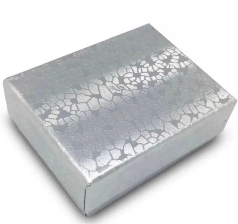 May include: A silver jewelry box with a textured, patterned design.