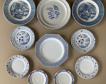 May include: A set of ten blue and white ceramic plates with floral and geometric designs. The plates are arranged in a circle on a light brown surface.