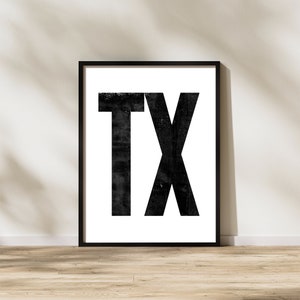 May include: Black and white framed print with the text "TX" in a bold, distressed font.