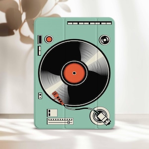 May include: A teal tablet case featuring a retro turntable design. The case has a black vinyl record with an orange center, a red tone arm, and various control buttons. The design is a stylized illustration, perfect for music lovers.