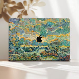 Könnte beinhalten: Laptop-Skin mit einem impressionistischen Dorfmotiv in Blau-, Grün- und Gelbtönen, das an ein Gemälde von Van Gogh erinnert. Das Apple-Logo ist sichtbar. Ein farbenfrohes, künstlerisches Design.