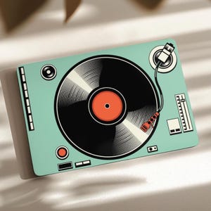 May include: A rectangular flat object featuring a graphic illustration of a mint green turntable with a black vinyl record, a red center label, a tonearm, and various control knobs and sliders depicted in a clean, stylized, two-dimensional design.