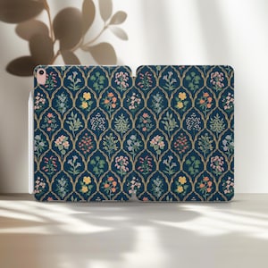 May include: Navy blue iPad case with a floral pattern. The case features a repeating design of flowers and foliage in shades of pink, yellow, and white, set against a dark blue background. The design is framed by gold-colored arches.