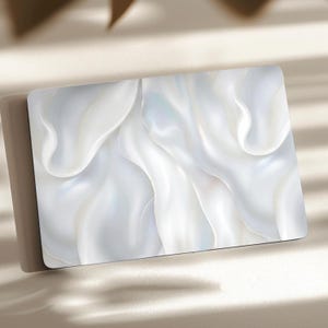 May include: A rectangular card featuring a high-gloss finish with a printed design of flowing white silk fabric. The surface displays soft, undulating folds and curves in shades of bright white, pearl, and subtle light gray with a smooth texture.