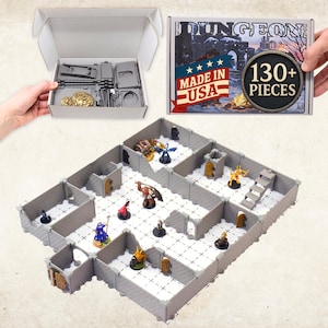 May include: A tabletop dungeon terrain set featuring modular gray stone walls, a white grid floor, and various miniature figures. The set includes over 130 pieces, packaged in a box labeled Dungeon with a Made in USA flag graphic and 130+ pieces text.