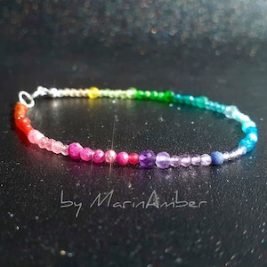 Peut inclure: Un bracelet en pierres précieuses arc-en-ciel avec des perles rouges, orange, jaunes, vertes, bleues, indigo et violettes. Le bracelet est fait de métal argenté.