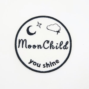May include: White embroidered patch with a black outline. The patch features a crescent moon, a star, a cloud, and the text "Moon Child you shine".