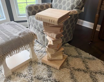 Mesa lateral com livros empilhados, 74 cm de altura.