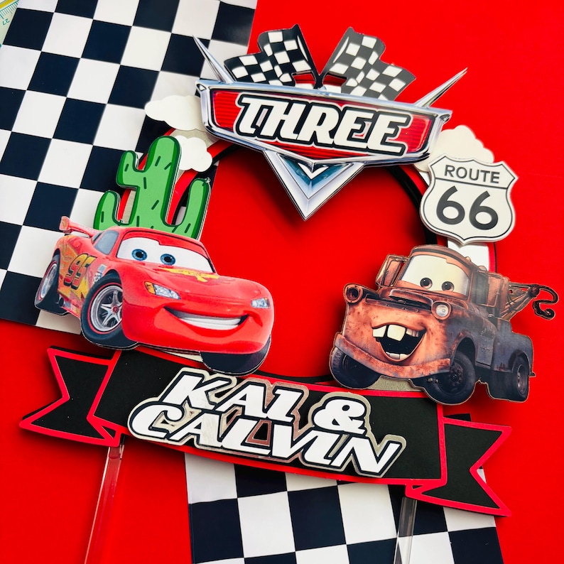 May include: A red and yellow race car and a rusty tow truck with a toothy grin, along with a cactus, checkered flag, and a sign that says "Route 66". The banner says "Kai & Calvin" with a black and red background.