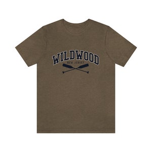 May include: A brown t-shirt with a navy blue graphic of the text "WILDWOOD NEW JERSEY" in an arched font with two crossed oars underneath.