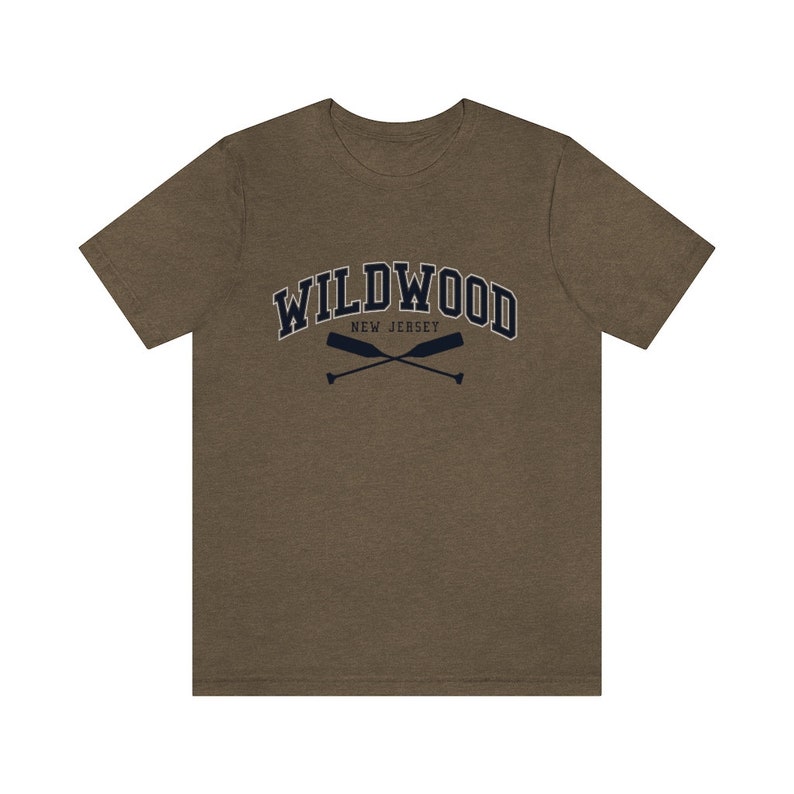May include: A brown t-shirt with a navy blue graphic of the text "WILDWOOD NEW JERSEY" in an arched font with two crossed oars underneath.