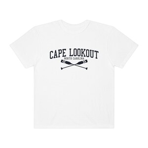 K&ouml;nnte beinhalten: Wei&szlig;es T-Shirt mit einer marineblauen Grafik, auf der "CAPE LOOKOUT NORTH CAROLINA" mit zwei gekreuzten Rudern steht.