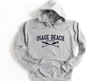 May include: Gray hooded sweatshirt with a navy blue print that says "Osage Beach Missouri" with two crossed oars.