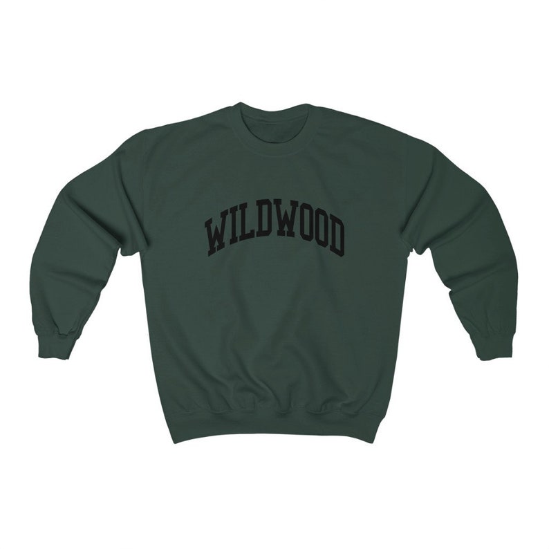 May include: A dark green sweatshirt with the word "WILDWOOD" arched across the chest in black block letters. The sweatshirt has a crew neck and long sleeves. The garment is made of a soft, comfortable material.