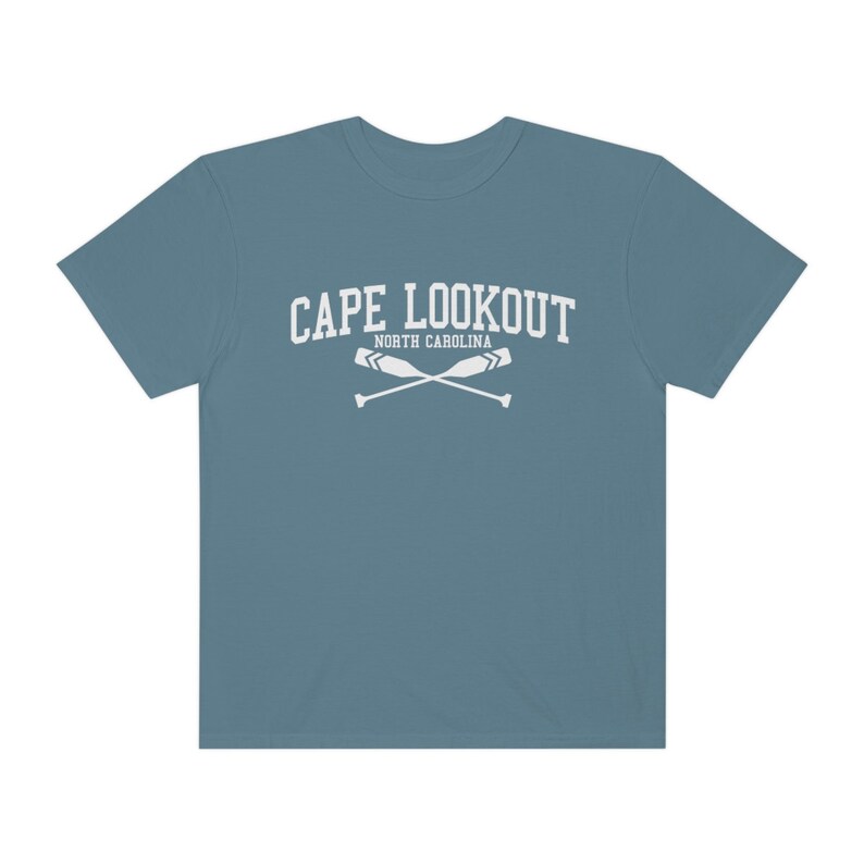 K&ouml;nnte beinhalten: Ein blaues T-Shirt mit einer wei&szlig;en Grafik, auf der "CAPE LOOKOUT NORTH CAROLINA" mit zwei gekreuzten Rudern steht.