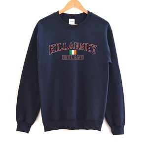 May include: Navy blue sweatshirt with the text "KILLARNEY IRELAND" in maroon with a small Irish flag graphic.