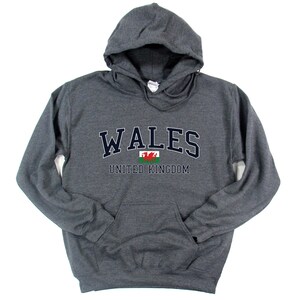 Puede incluir: Sudadera con capucha gris con el texto "WALES UNITED KINGDOM" y una bandera de drag&oacute;n rojo.