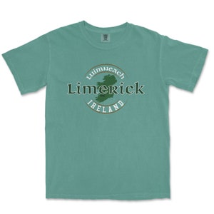 May include: A teal blue t-shirt with a green circle graphic featuring the text "Limerick, Ireland" and a green outline of Ireland.