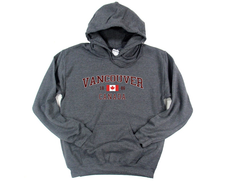 May include: A dark gray hooded sweatshirt with a maroon print that says "Vancouver 1886 Canada" with a Canadian flag in the middle.